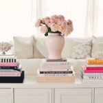 A stylish white coffee table featuring an assortment of books, inviting relaxation and reading in a modern room.