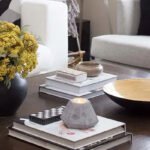 A coffee table set with various books and a colorful vase of flowers, enhancing the room's decor.