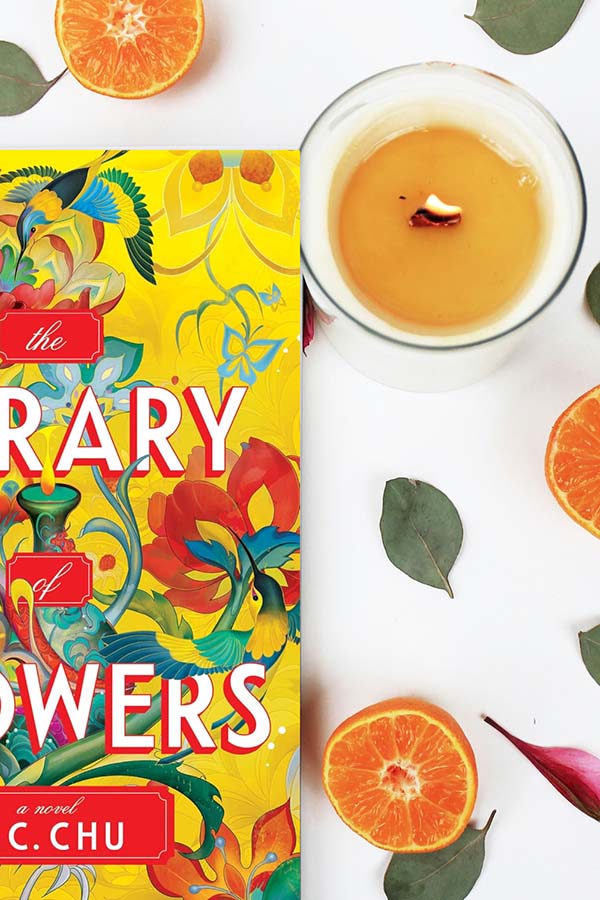 Oranges, a candle and half the cover of The Library of Flowers book