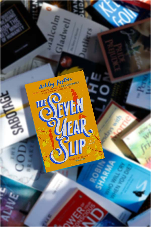 Pile of books with The Seven Year Slip by Ashley Poston in focus