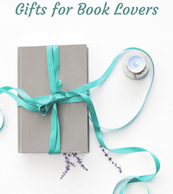 Grey book wrapped with a teal ribbon next to a candle and some lavendar on a white background with the text overlay "Gifts for Book Lovers"